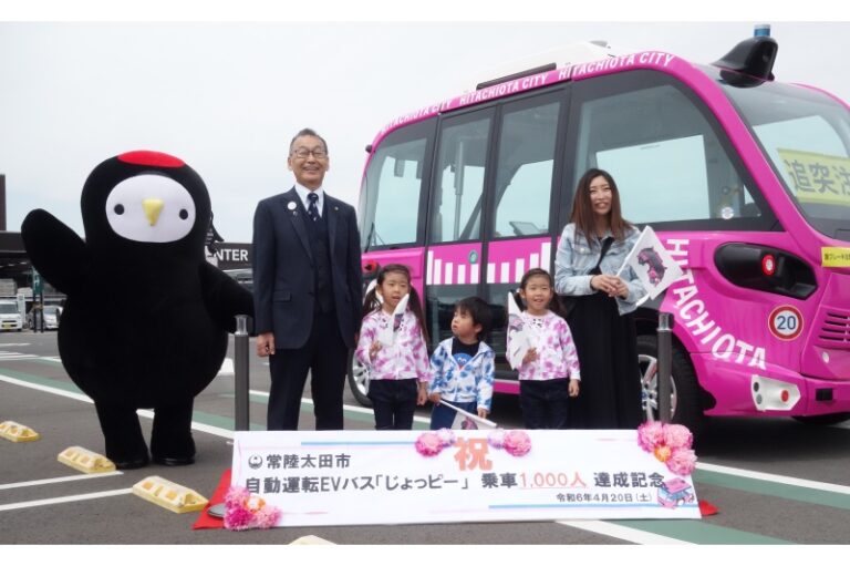 茨城県常陸太田市の自動運転EVバス「じょっピー」乗車1000人達成式典で撮影 左から市のマスコット「じょうづるさん」、宮田達夫市長、1000人目の會澤さんご家族