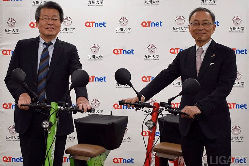電動三輪モビリティの実証実験を開始、九州大学の石橋達朗総長(左)とQTnetの岩﨑和人社長(右)