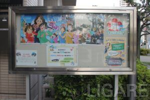 本社前の掲示板には車庫見学の受け付け番号や「バスと一緒に写真を撮ろう!」のポスターが見える